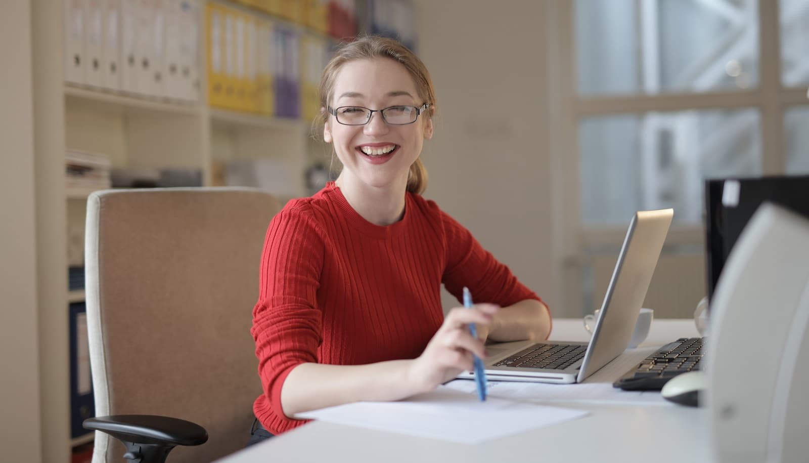 Student smiling while typing on her laptop