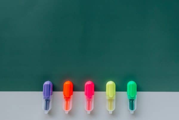 Highlighters in a row on a dark green background