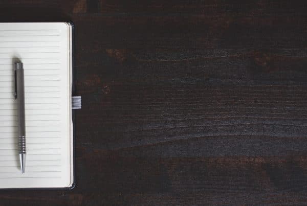 Open blank notebook on wooden table