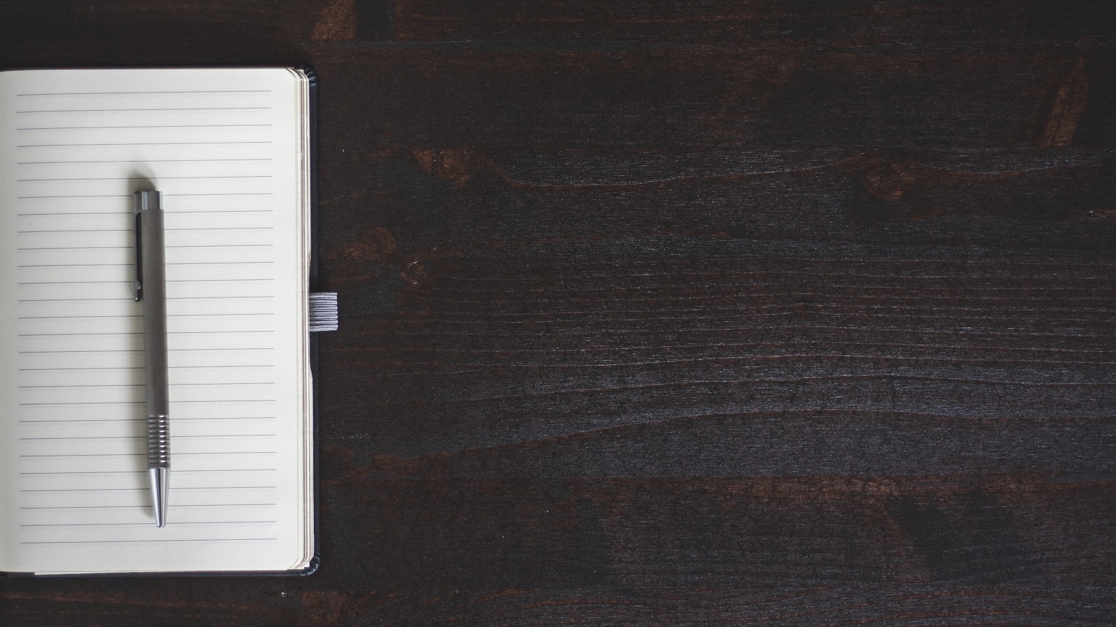 Open blank notebook on wooden table