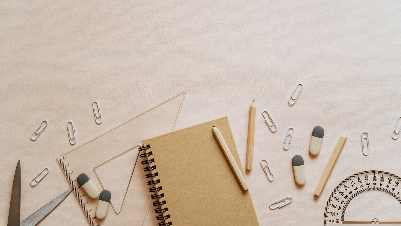 Beige flay lay of notebook, paperclips, and prostrators