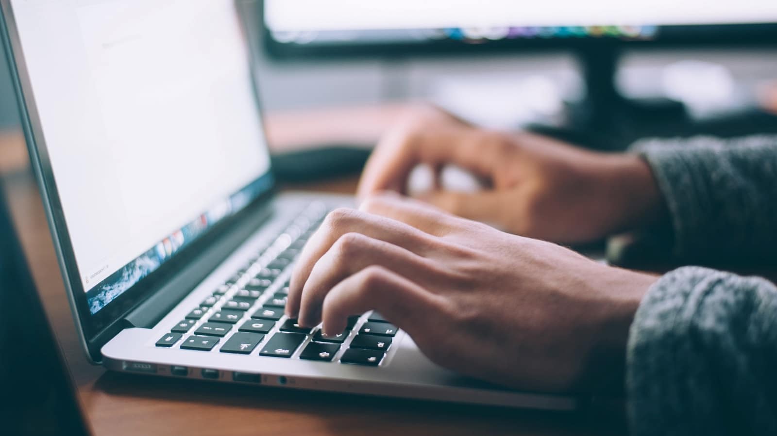 Person typing on a laptop keyboard