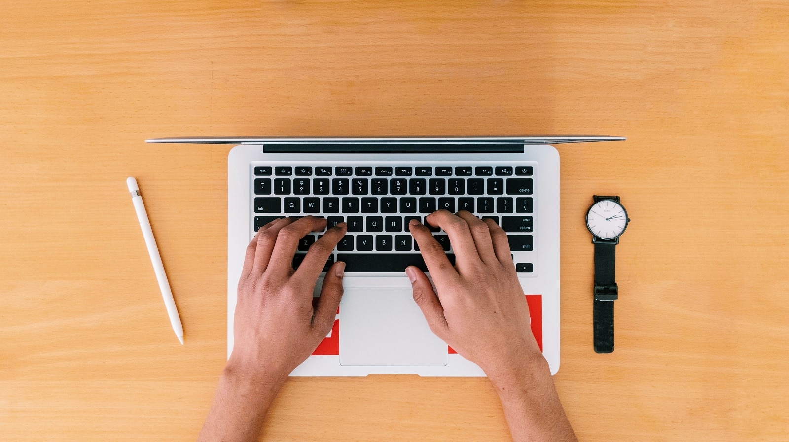 Hands typing on a laptop from aerial perspective