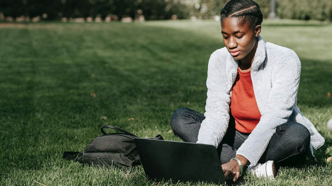 Girl studying from laptop on lawn