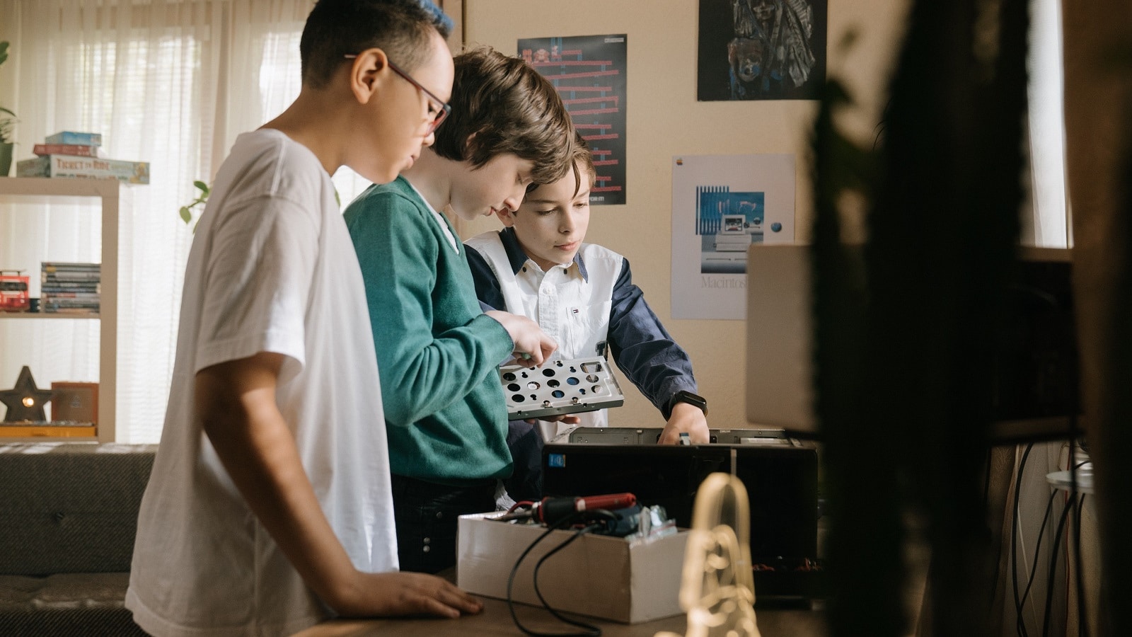 Three young students study a computer system