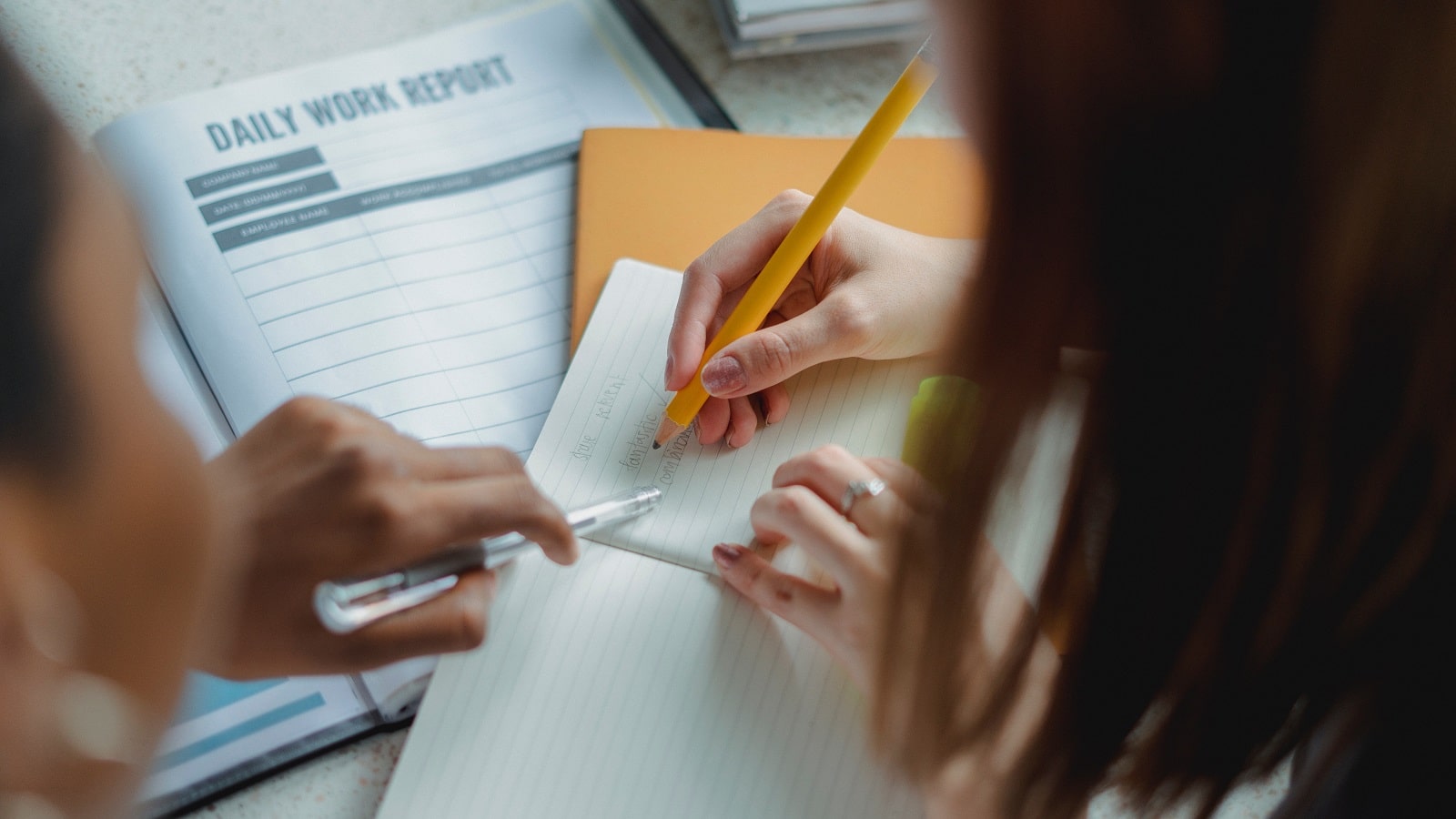 Overhead photo of two women collaborating on a document