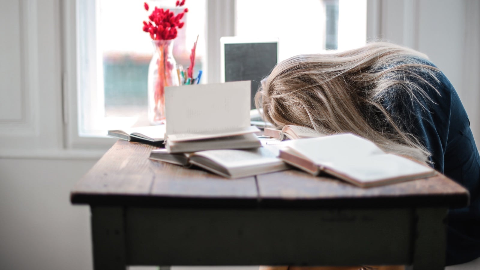 Student sleeping on textbooks