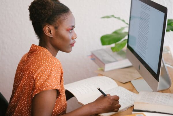 Woman taking notes from computer