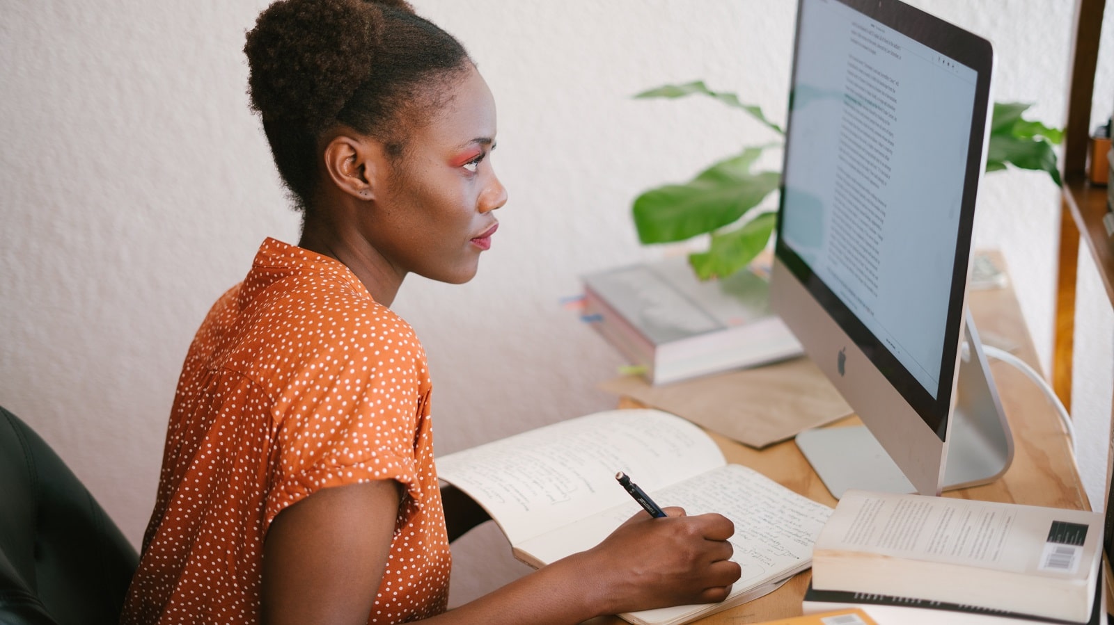 Woman taking notes from computer