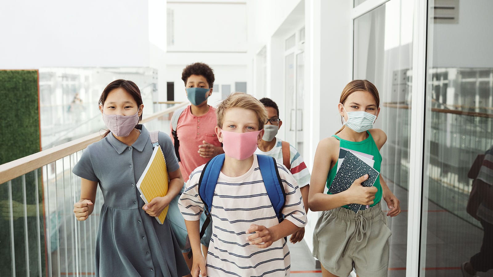 Five young students walking the hallways