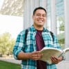Man in Blue Red and White Plaid Dress Shirt Holding a Book