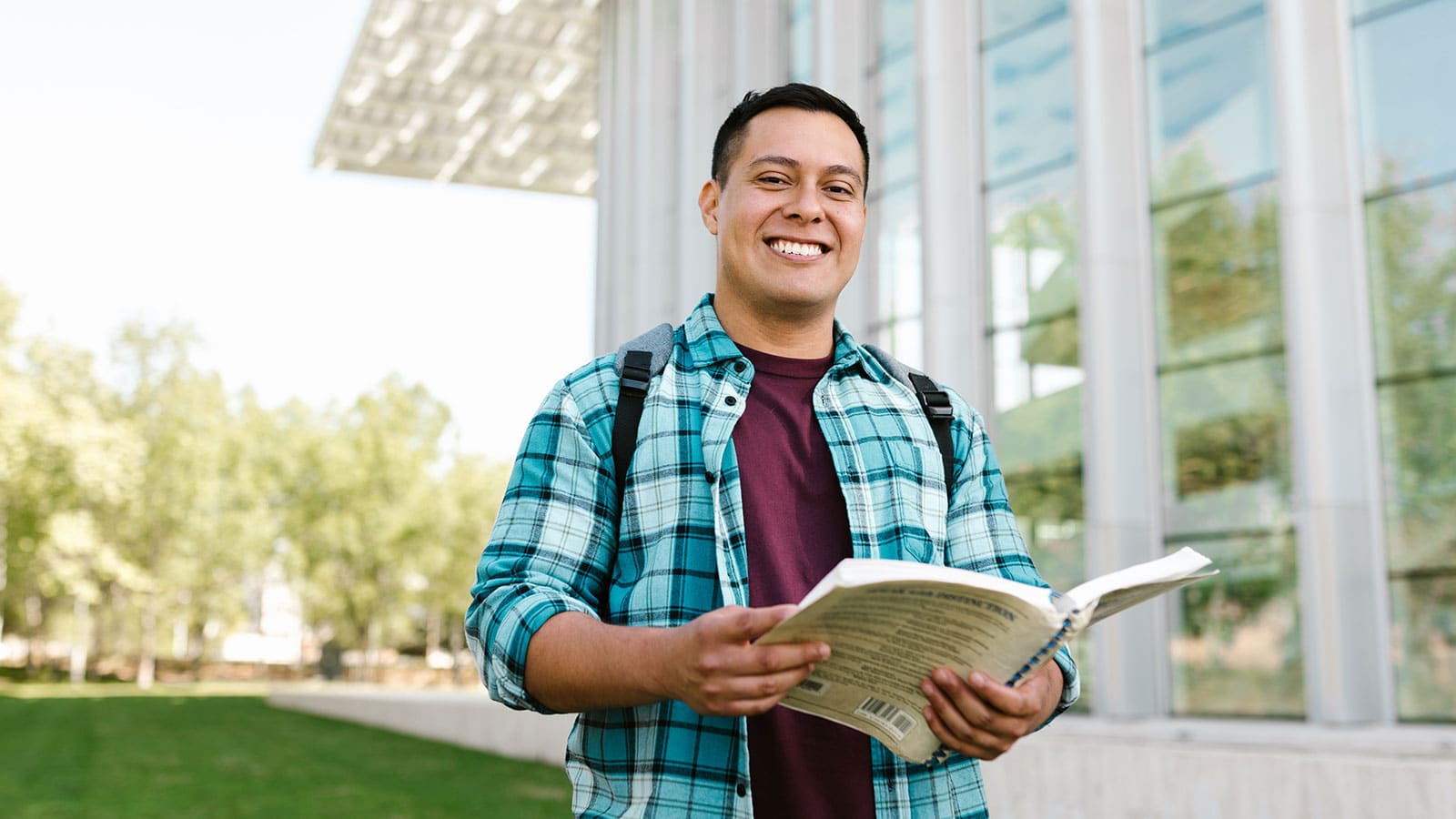 Man in Blue Red and White Plaid Dress Shirt Holding a Book