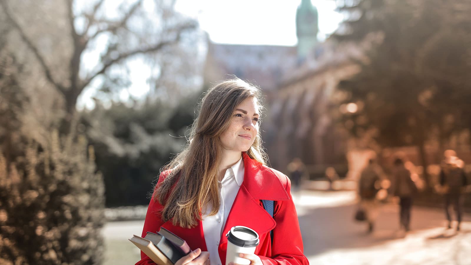 Woman in Red Coat Holding Notebooks and Coffee cup