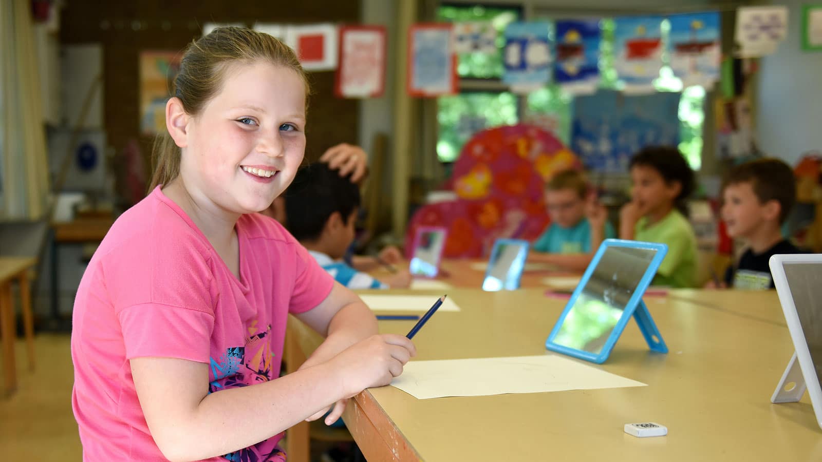 Girl in pink crew neck t-shirt holding a pen