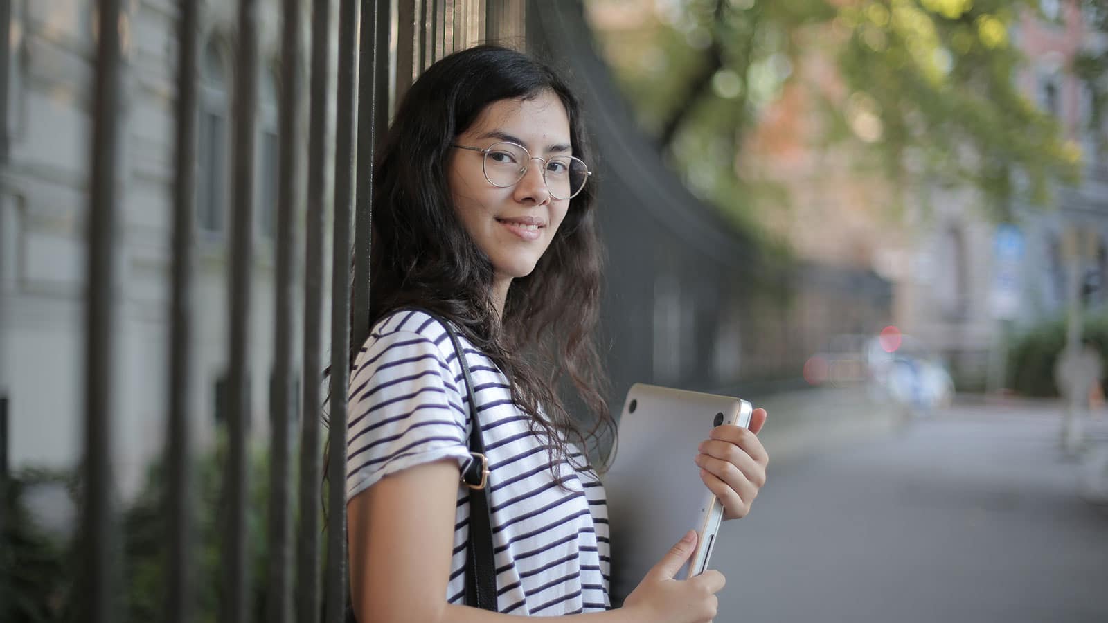 Woman in black and white striped shirt holding laptop