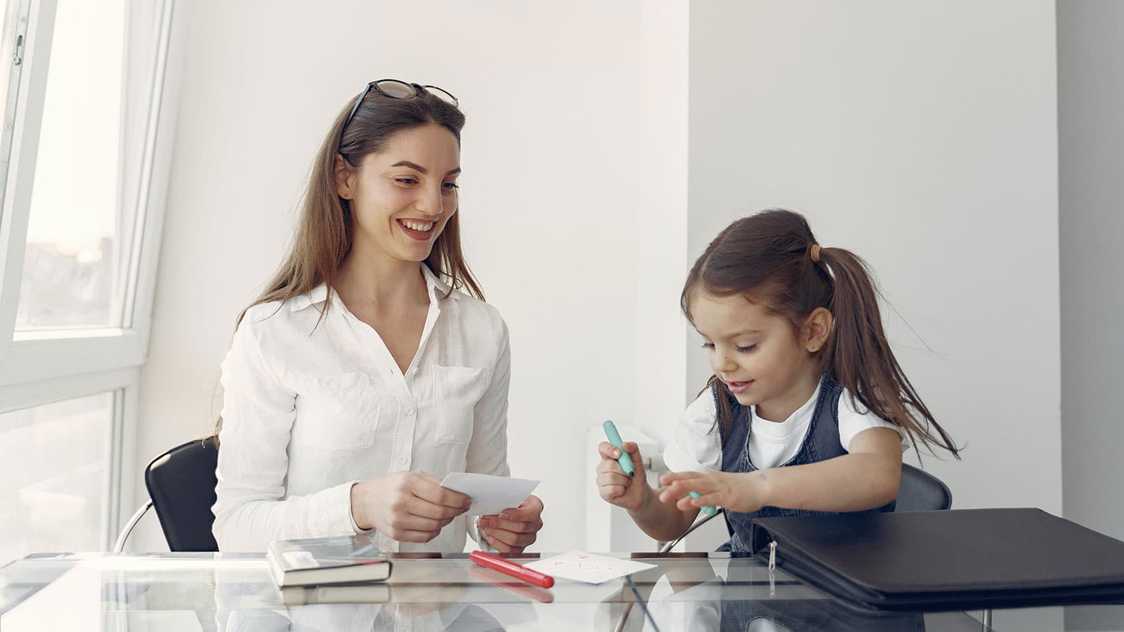 Happy mother and daughter studying in office