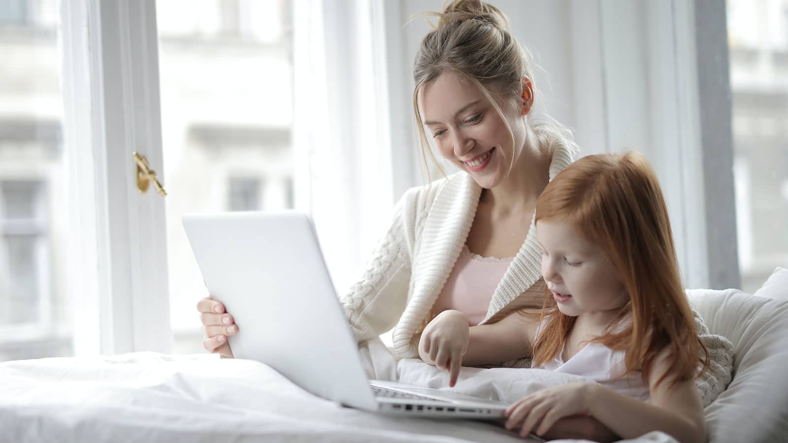 Photo of mom and little girl learning on a laptop