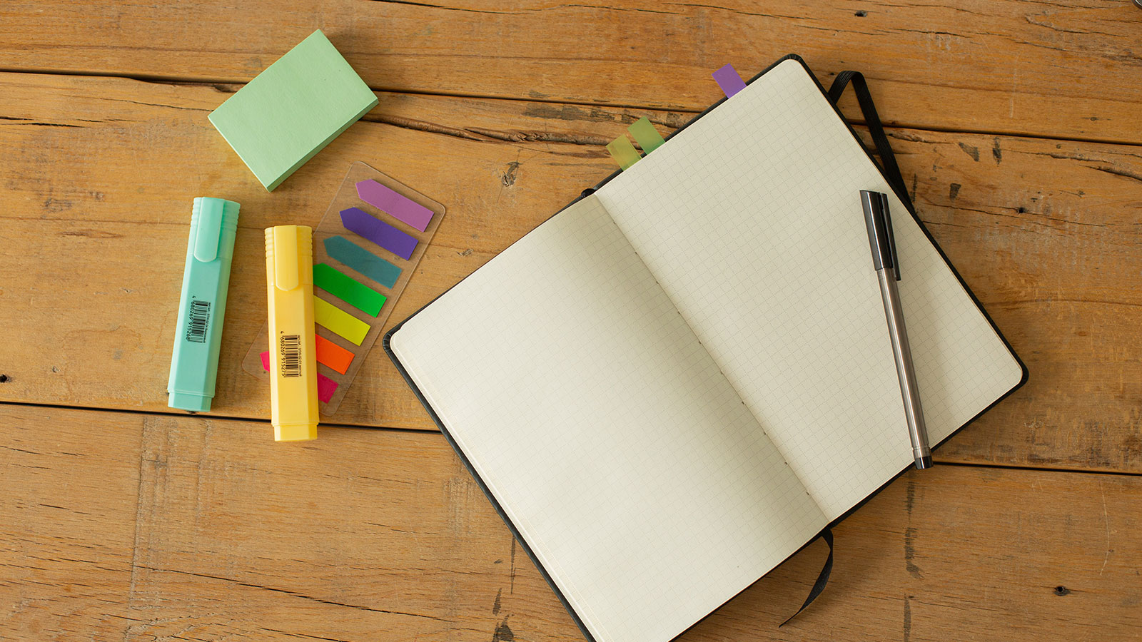 Opened notebook with white blank pages and pen on table