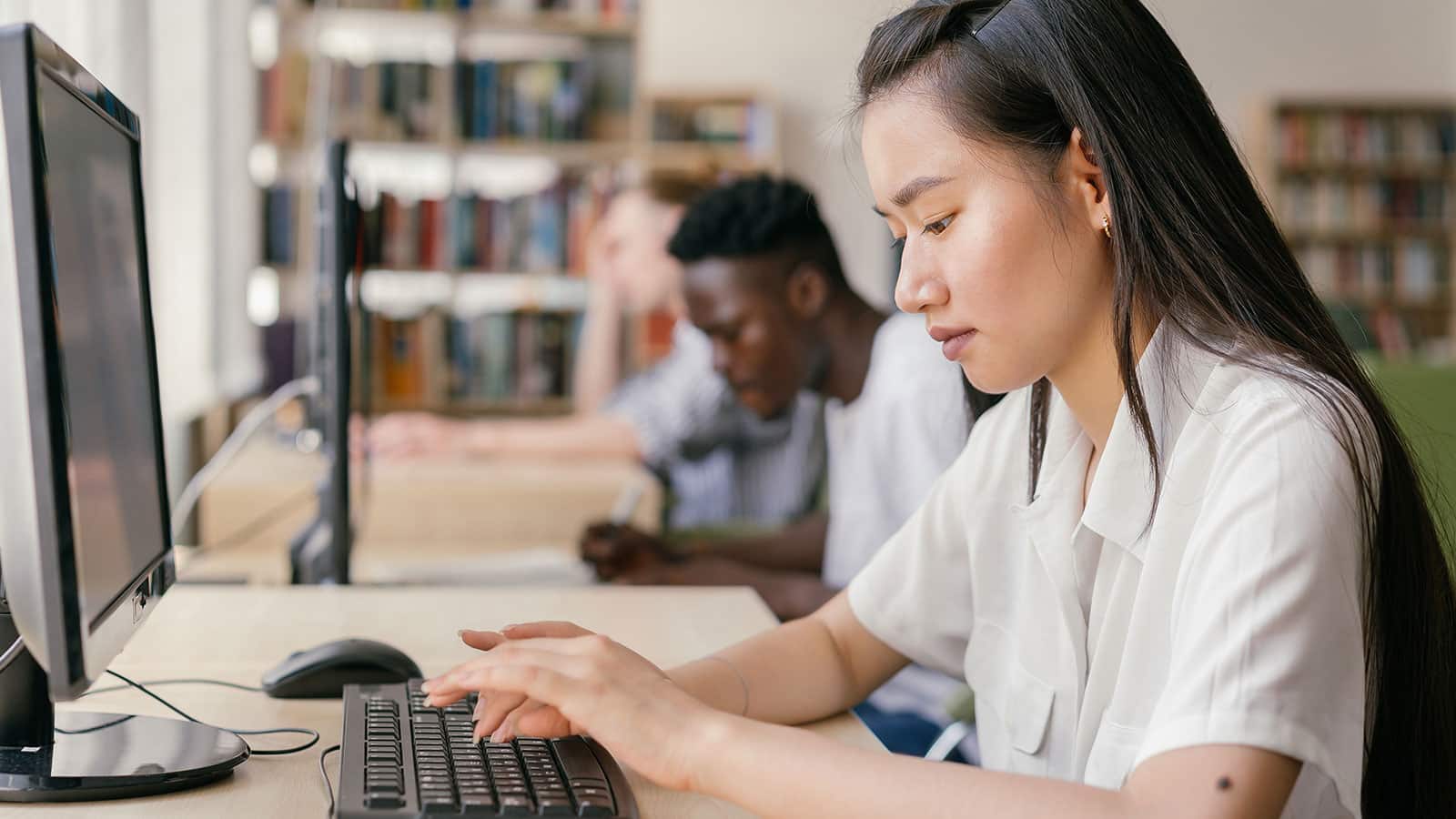 Female student typing in front of a screen