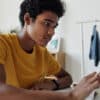 Student sitting and tapping on a tablet