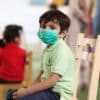 Child sitting in class with mask on