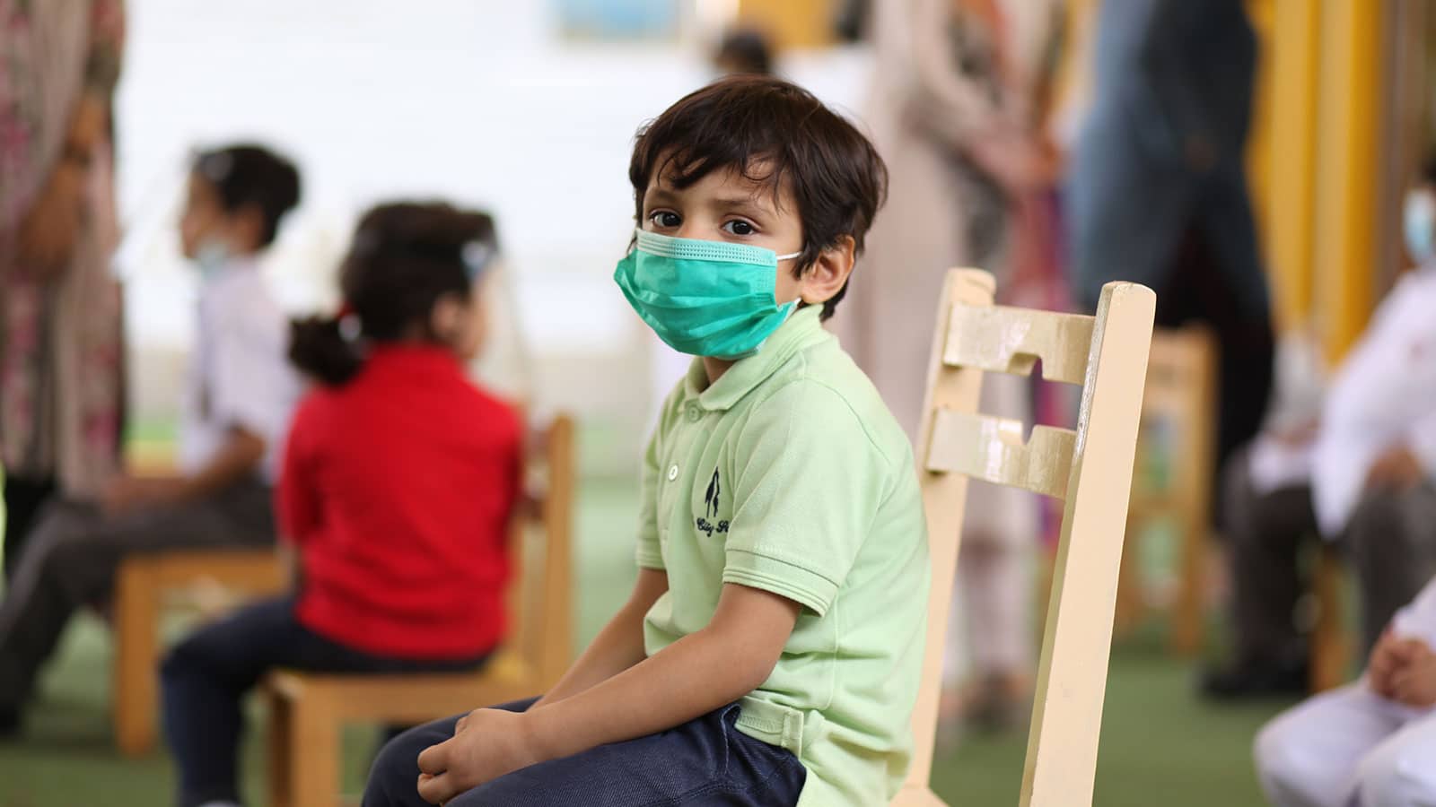 Child sitting in class with mask on