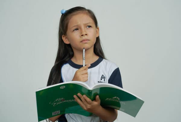 Girl holding a workbook with a pencil in her hand