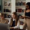 Three students in a room doing their classwork together
