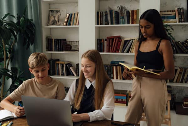 Three students in a room doing their classwork together