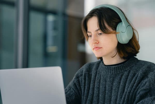 Student wearing headphones staring at a laptop screen